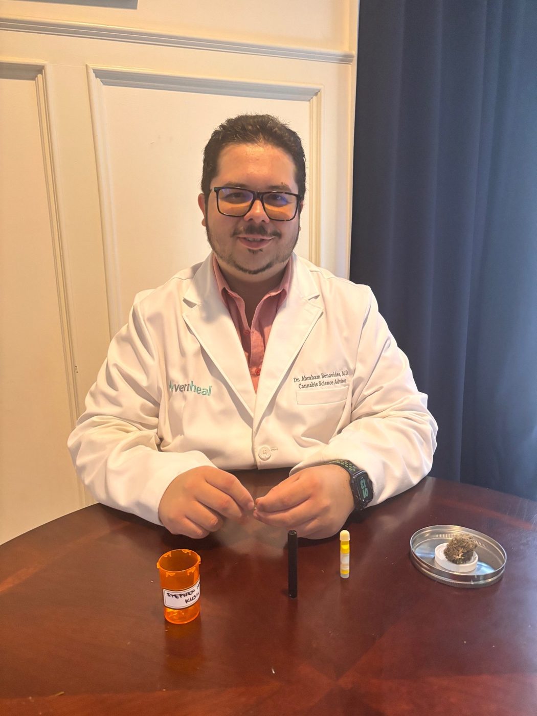 Dr. Abraham Benavides, MD, in a lab coat with a HALO cartridge and sample jar