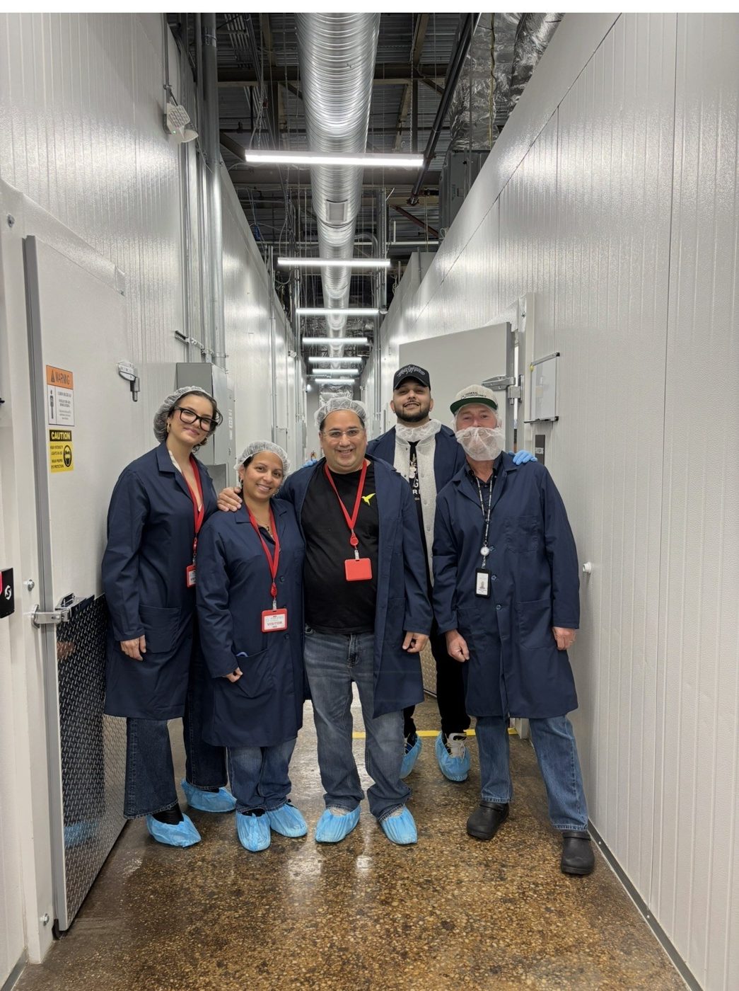 Frank Lopa and team in lab coats and shoe covers inside a cultivation facility